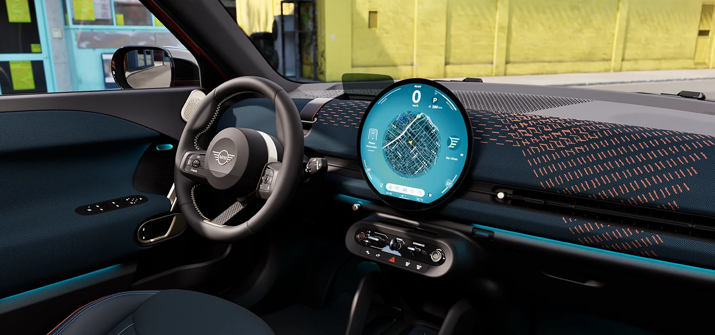 Interior view of the all-electric MINI Aceman with focus on the dashboard, the interaction unit and the steering wheel.