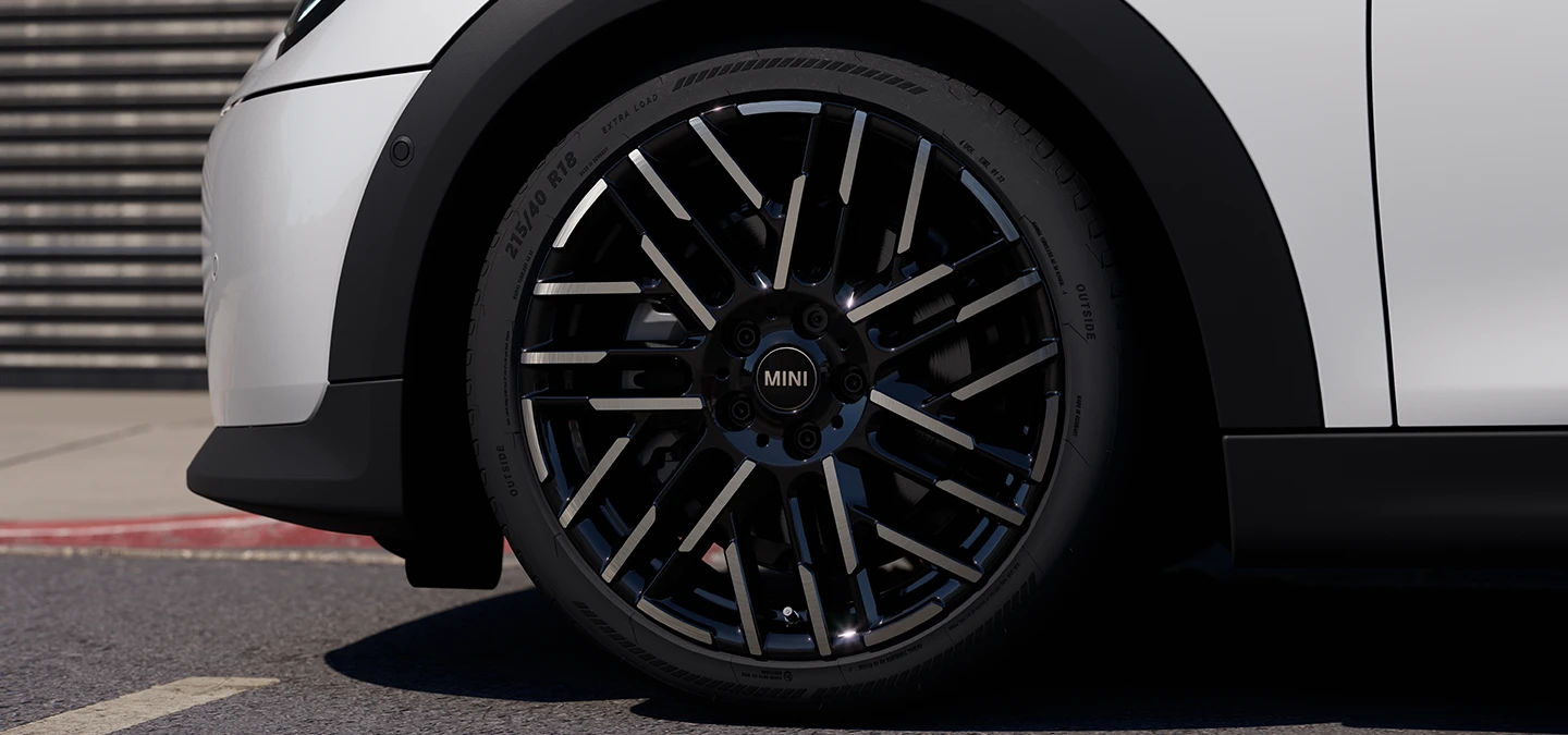 Close shot of the MINI Cooper 5-Door in Nanuq White with Night Flash Spoke 2-tone rims.