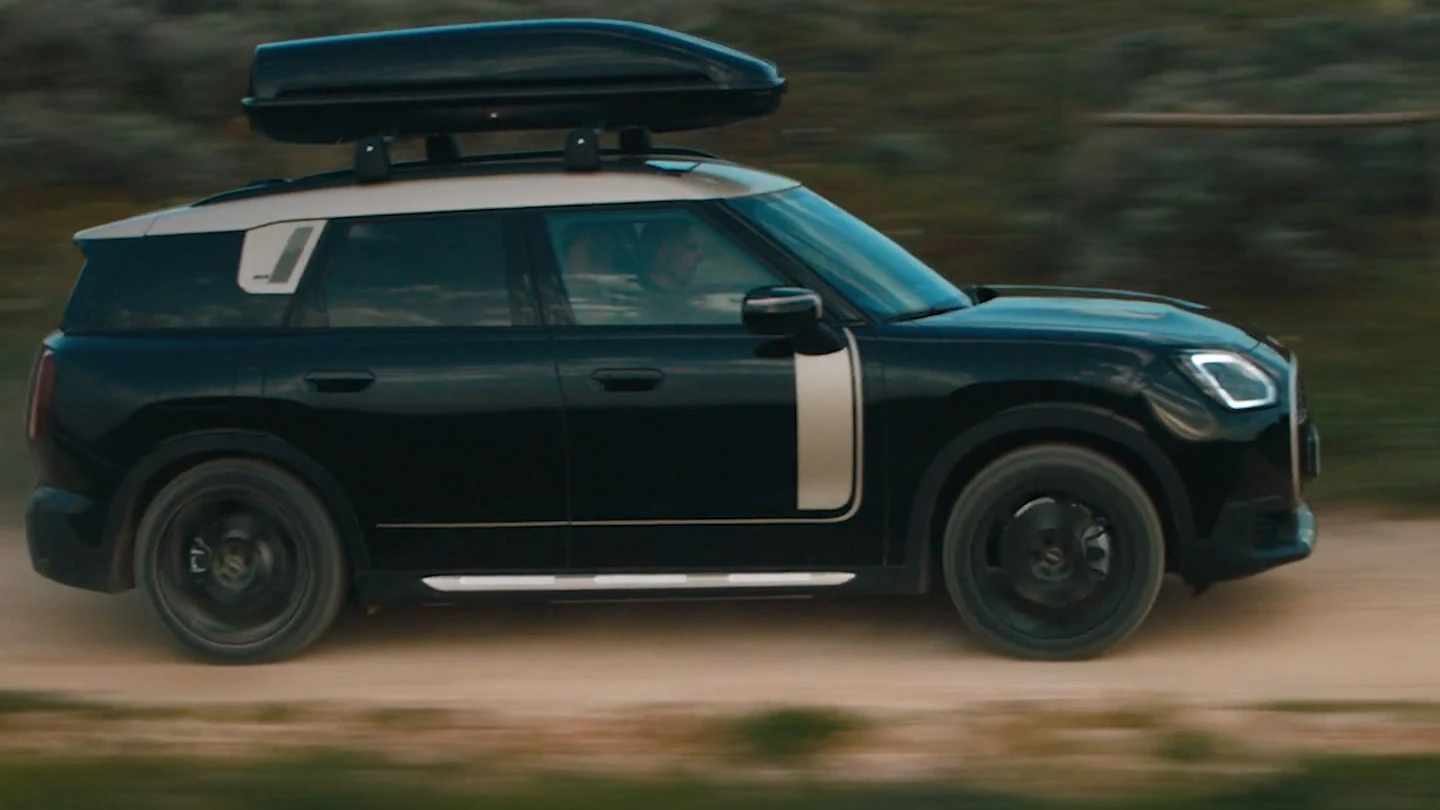 MINI Countryman in Midnight Black metallic with 19" John Cooper Works Runway Spoke Wheels in black, driving offroad. 