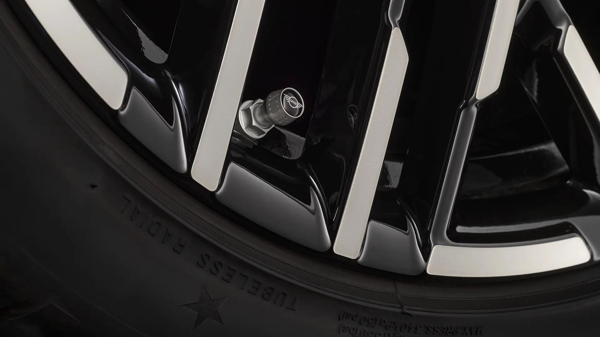 Close-up of black valve stem cap with the silver MINI wing logo.