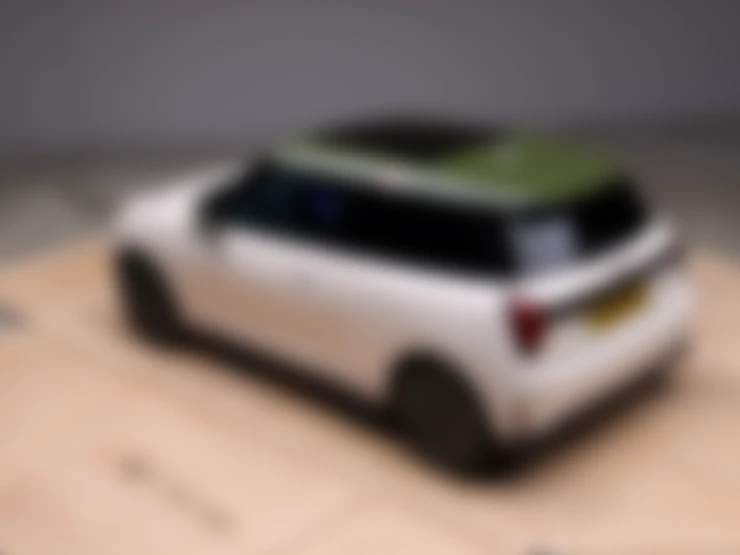 Top side view of the all-electric MINI Cooper Paul Smith Edition in Inspired White with contrast roof in Nottingham Green.