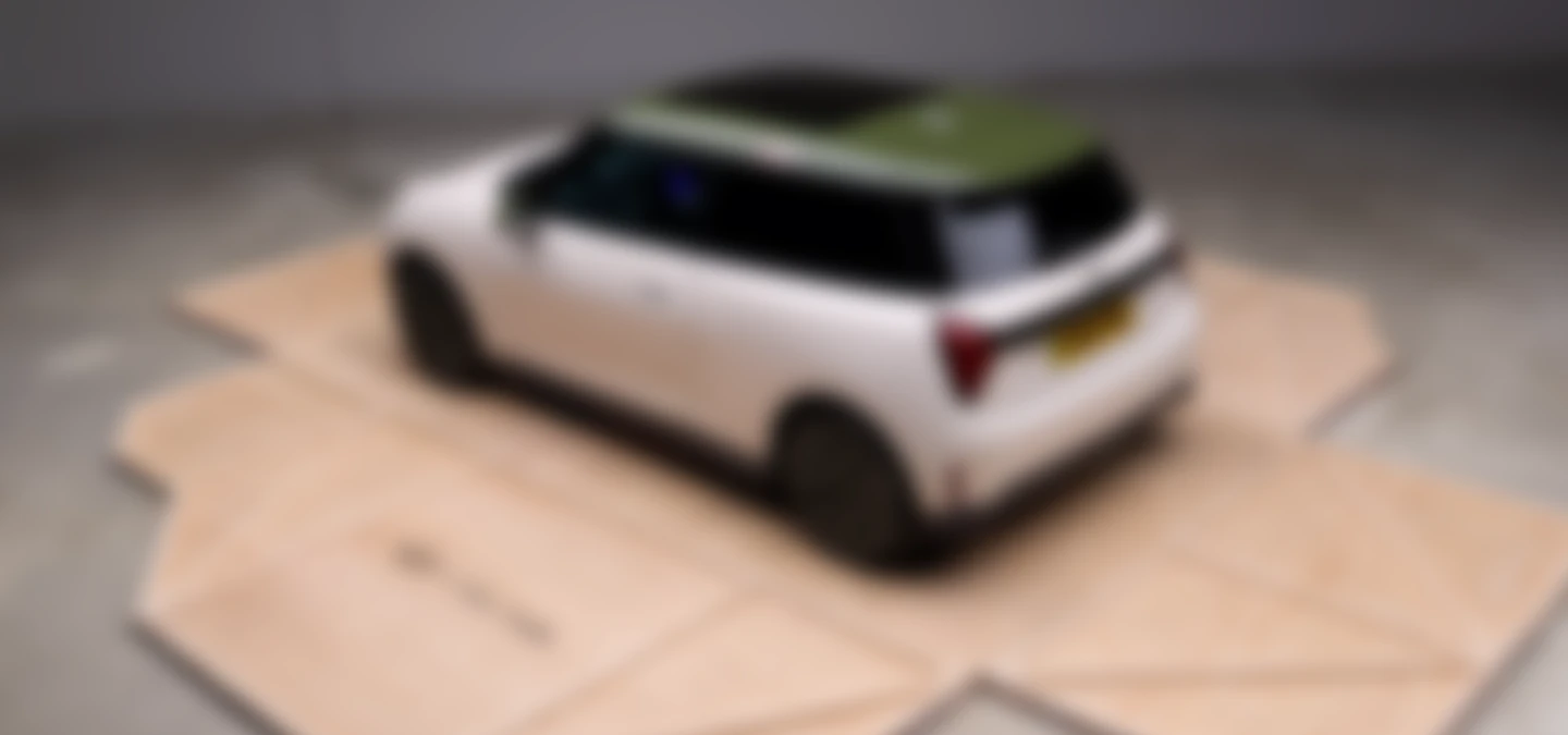 Top side view of the all-electric MINI Cooper Paul Smith Edition in Inspired White with contrast roof in Nottingham Green.