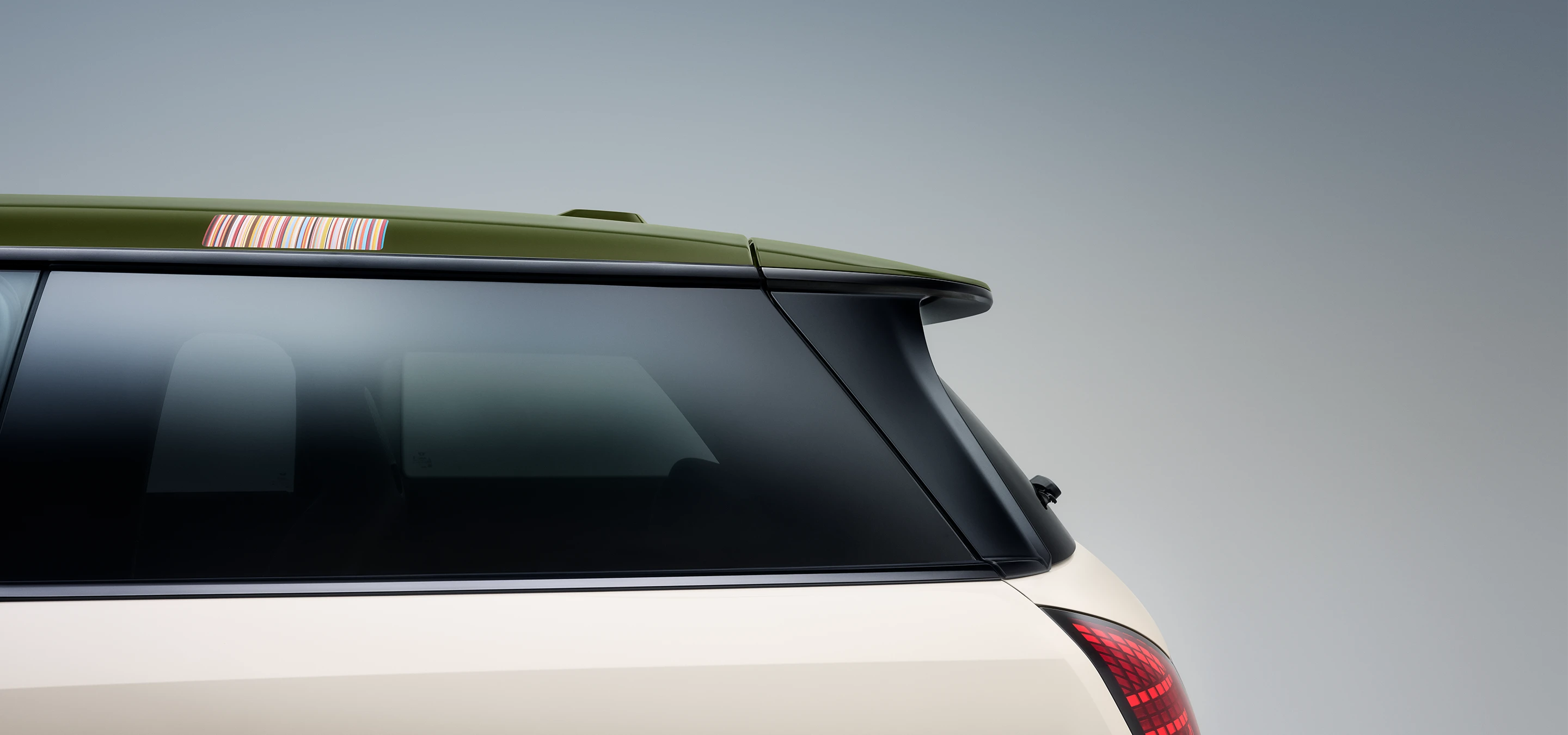 Front side view of the all-electric MINI Cooper Paul Smith Edition in Inspired White and contrast roof in Nottingham Green.